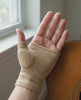 A hand wearing the beige knit thumb sleeve resting against an acoustic guitar, five second clip